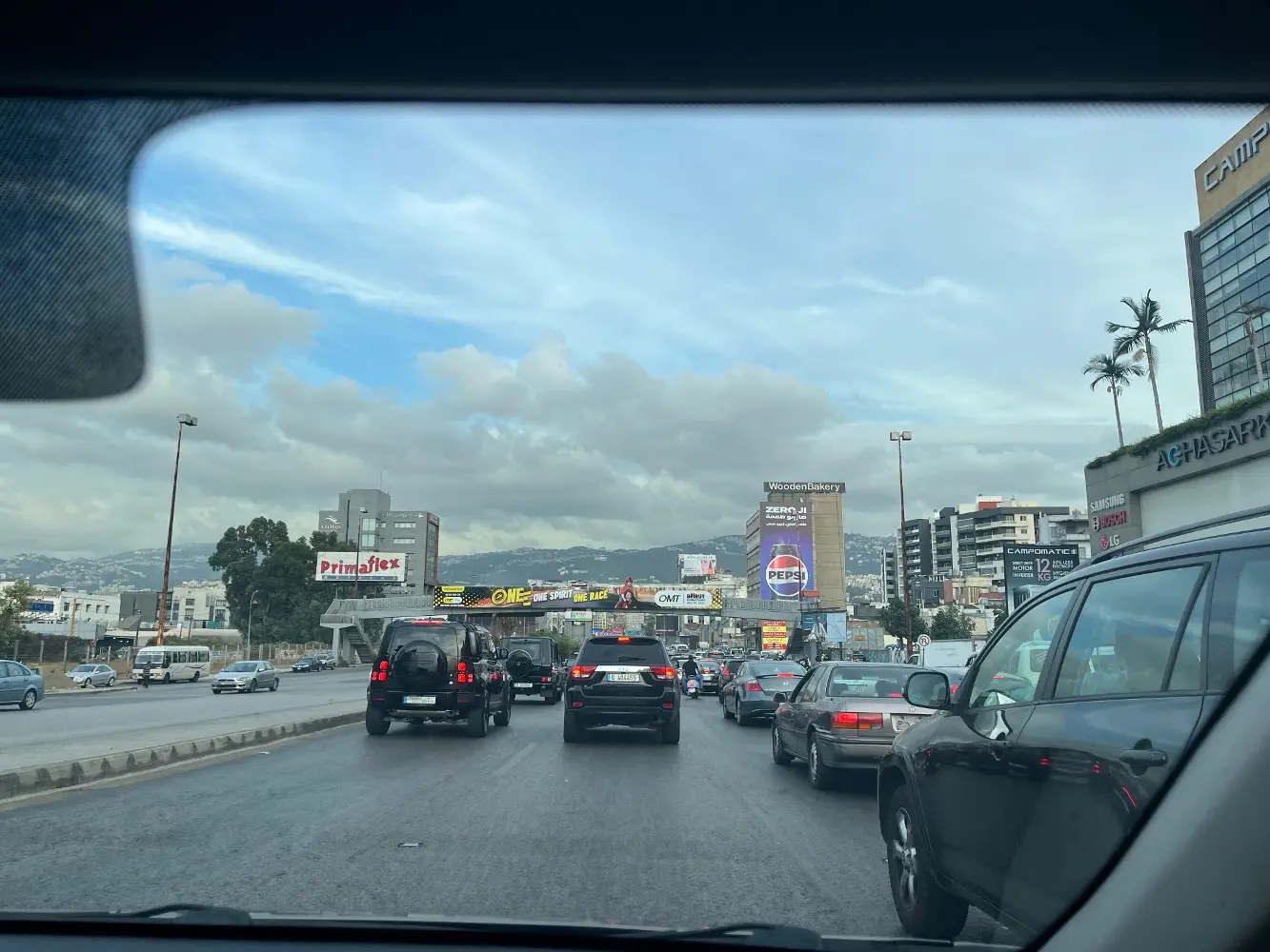 Araç içinden bir görünüm, 3 şeritli bir yol, durağan trafik, üst geçit görünüyor.